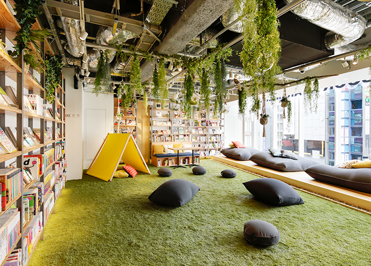 Espace de repos d'un bureau avec plantes suspendus et des coussins