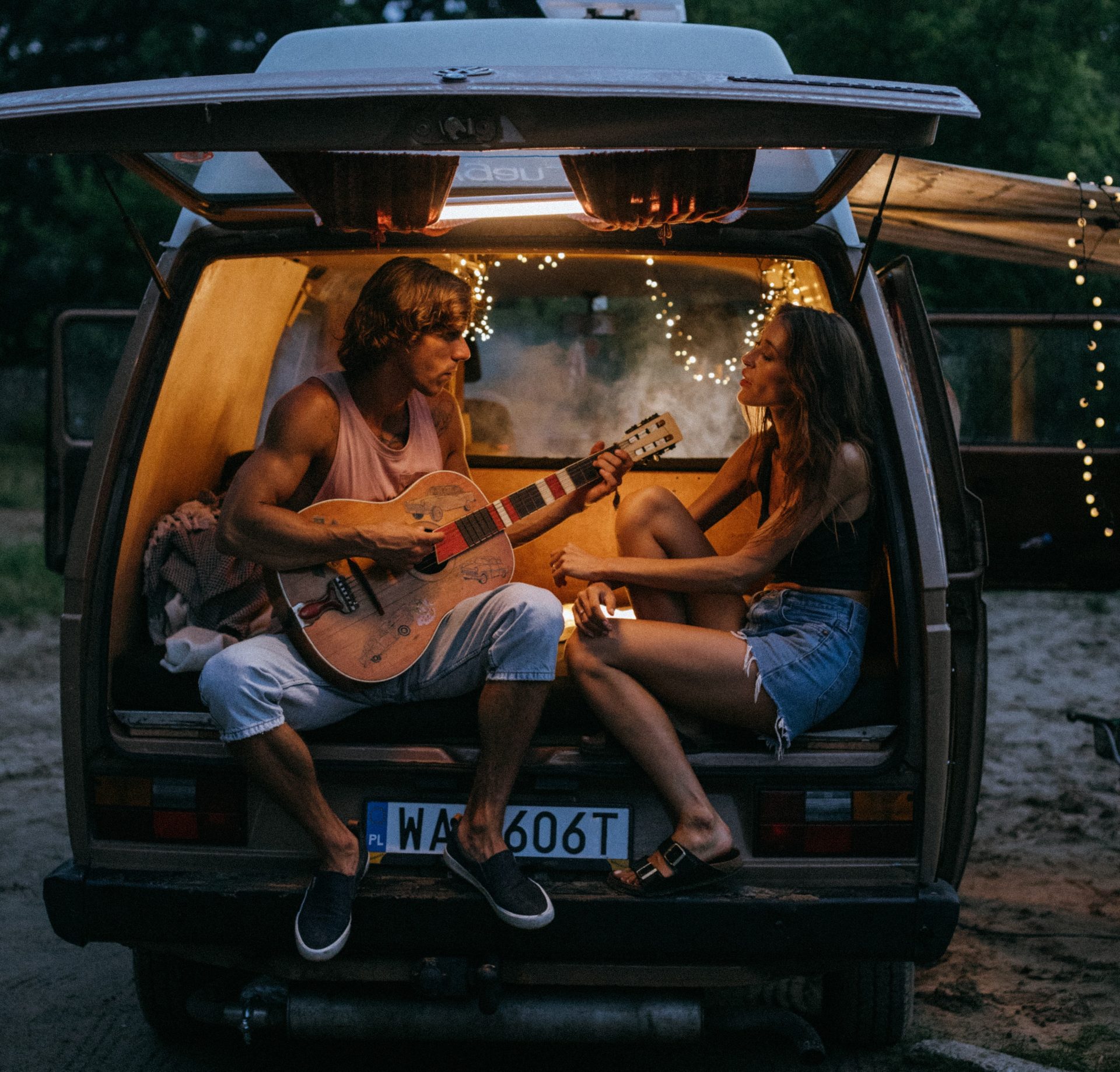 A couple in a there vehicle with RV lighting singing a song